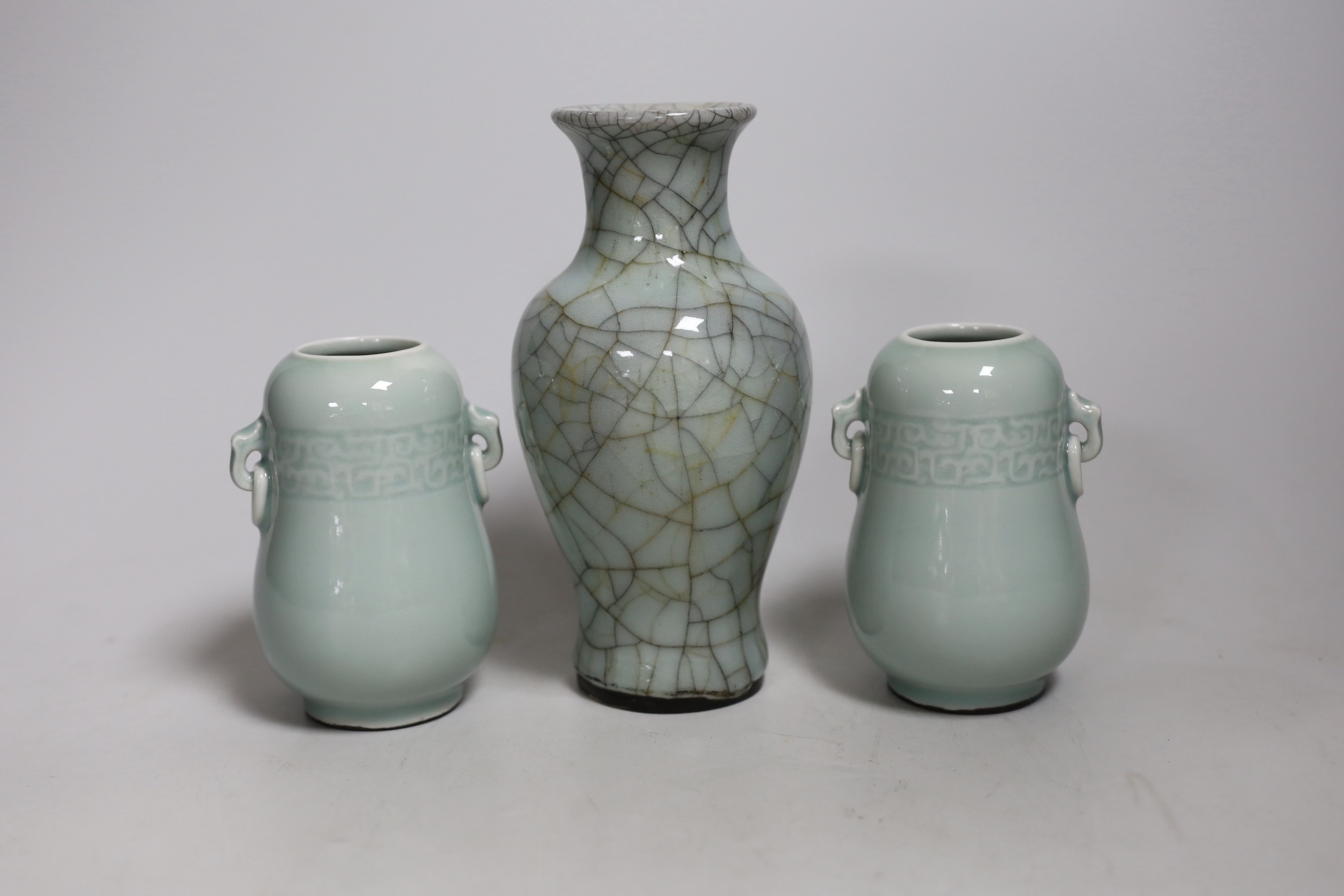 A Chinese celadon crackle ware vase and a pair of smaller celadon vases, largest 16.cms